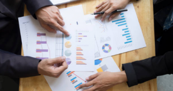 Charges foncières et prélèvement à la source : que puis-je déduire ? deux personnes avec documents graphiques statistiques sur une table