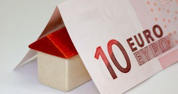 Tout savoir sur l’assurance loyer impayé Maison miniature sur laquelle repose des billets en euros