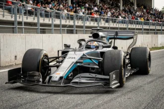 Monoplace de Formule 1 en pleine action sur un circuit moderne, vue en contre-plongée mettant en valeur l'aérodynamique et les pneus slicks