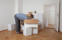 personne penchée la tête dans des cartons de déménagement