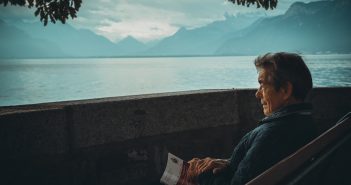 personne âgé au bord de l'eau sur un banc